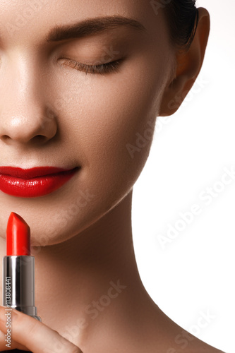 Close-up shot of woman lips with glossy red lipstick