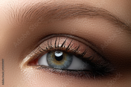 Fototapeta Naklejka Na Ścianę i Meble -  Elegance close-up of female eye with classic dark brown smoky make-up