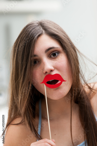 Young woman holding photo booth lips