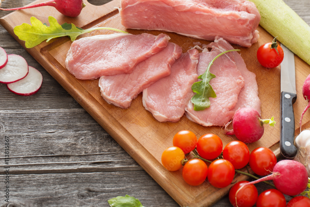 raw meat with fresh vegetables on wooden surface raw meat with fresh vegetables on wooden surface