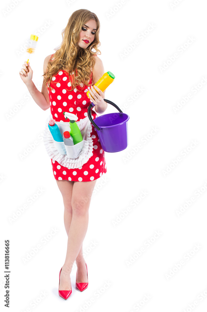 Blonde girl in a red dress housewife with curlers in the house cleaning. Housekeeper with cleaning tools: a bucket, a mop, detergents, isolated on white background. Blonde girl in a red dress housewife with curlers in the house cleaning. Housekeeper with cleaning tools: a bucket, a mop, detergents, isolated on white background.