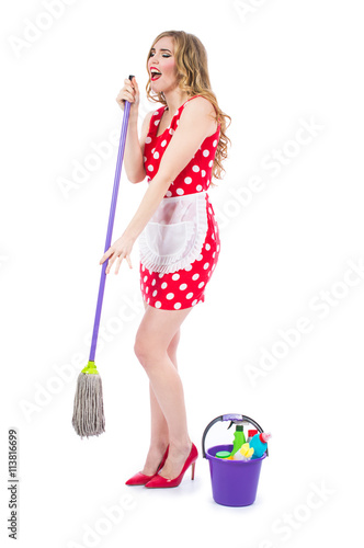 Blonde girl in a red dress housewife with curlers in the house cleaning. Housekeeper with cleaning tools: a bucket, a mop, detergents, isolated on white background.