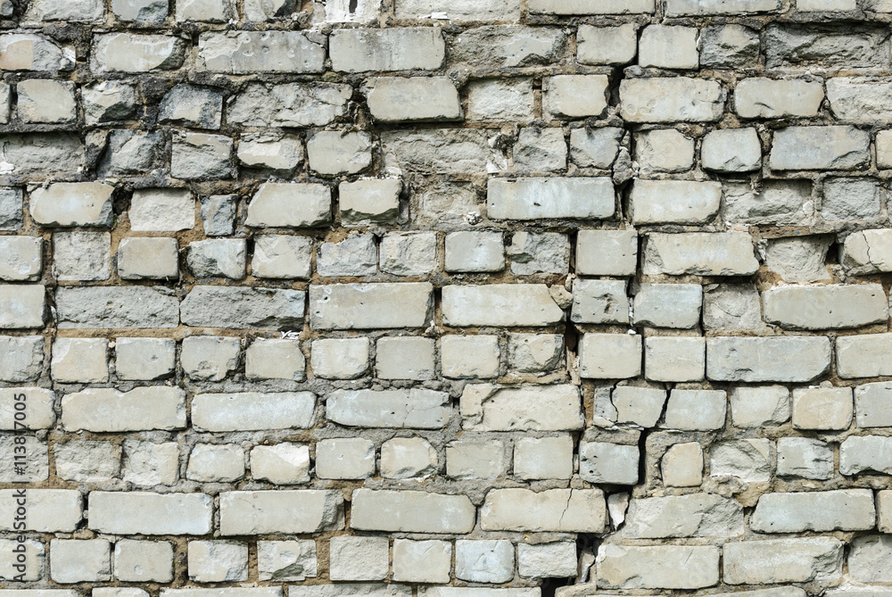 Obraz premium Old white brick wall with cleft