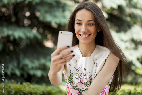 Smiling woman take a picture of herself with a smartphone. selfi