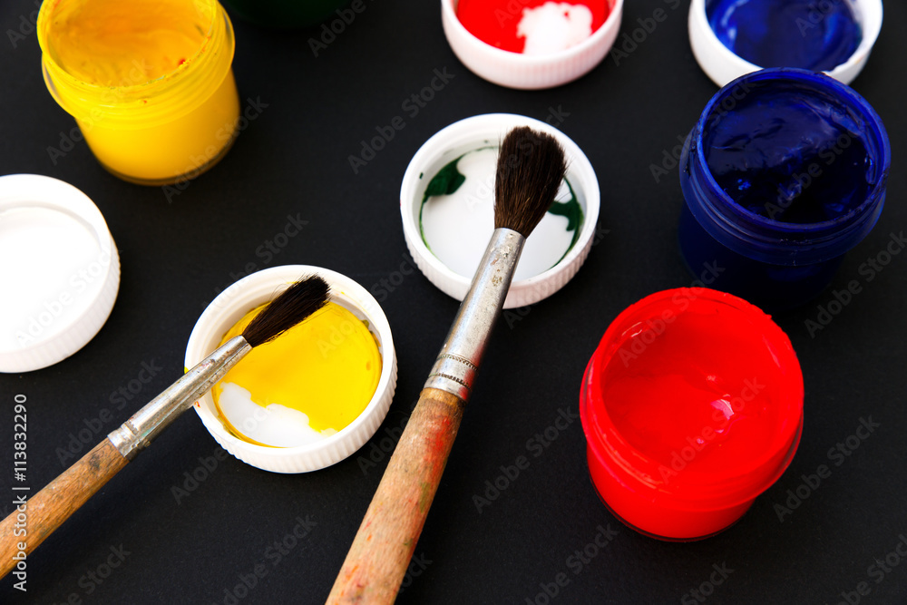 Gouache colors and paint brushes on black background Gouache colors and paint brushes on black background