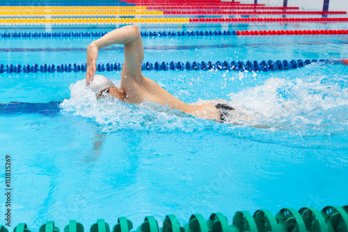Man swimmer swimming crawl in blue water.