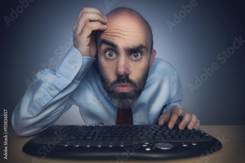 Photos Mann sucht Fehler am Computer