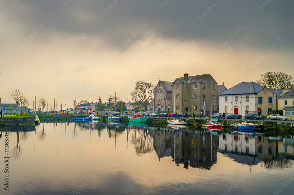 Cloudy sunset over the Galway Dock, with fishing boats and Dominican church