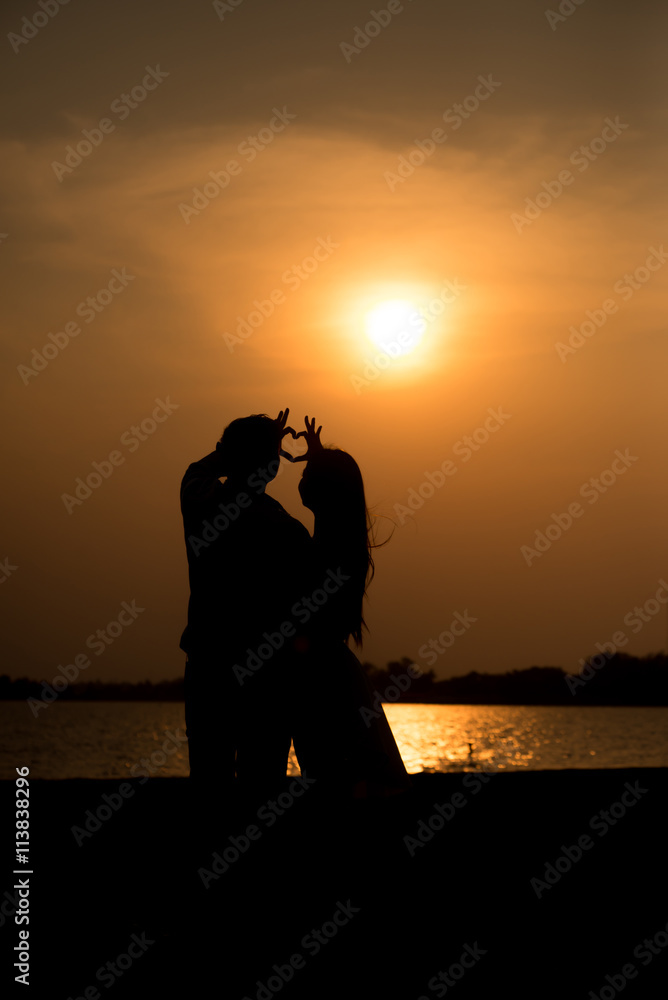 Couple make hands heart symbol shaped with beautiful sunset  nature on background