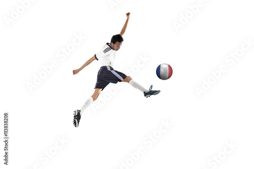 Soccer player jumping while kicking the ball