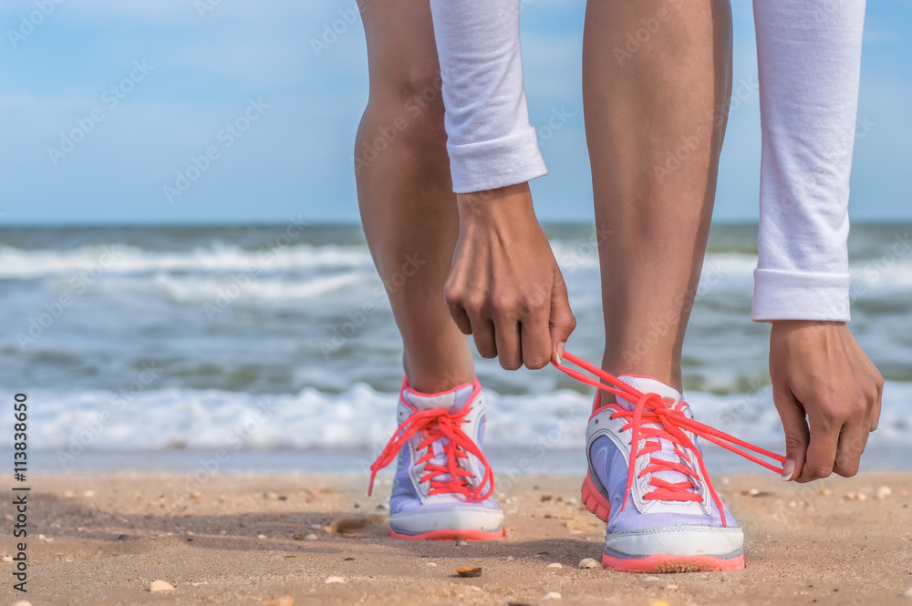 Girl jogging on the beach, running shoes