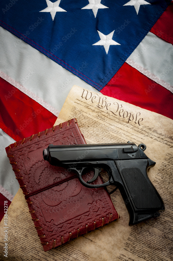 Image of an American flag with a Bible and a hand gun pistol on it