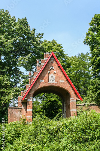 Rotes Tor aus Klinkersteinen im Wald bei einer Abtei in Belgien