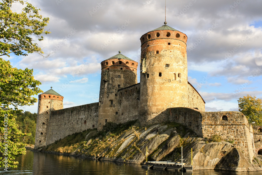 Ancient fortress Olavinlinna in Savonlinna in Finland among the trees a summer day.