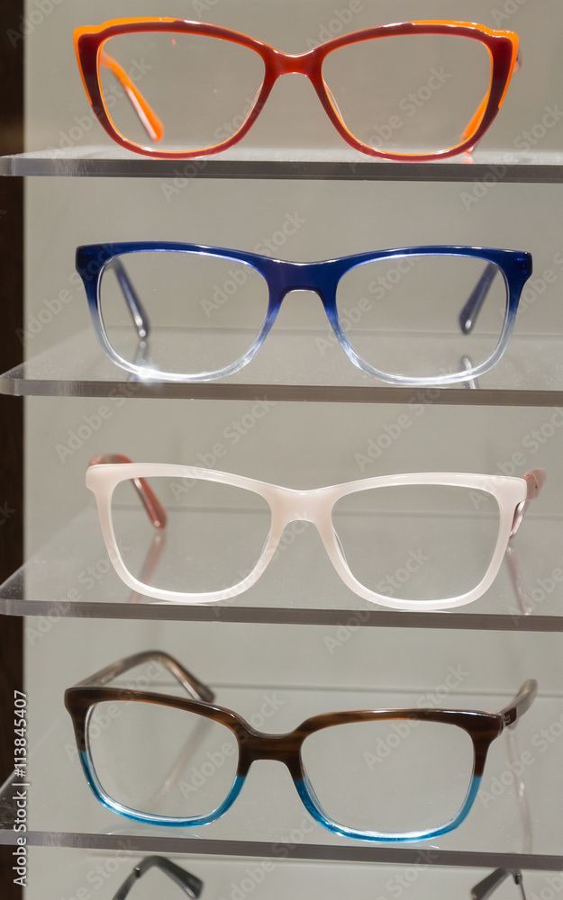 Gafas con monturas de colores colocadas en un expositor para la venta  Photos | Adobe Stock