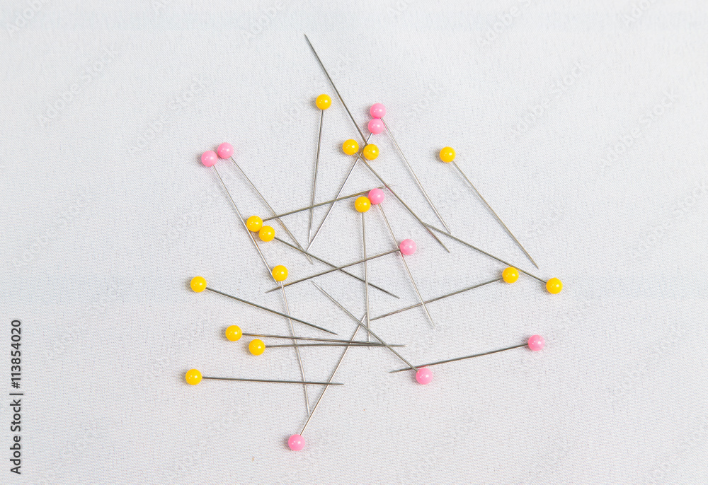 Many pins for needle work on white fabric Many pins for needle work on white fabric