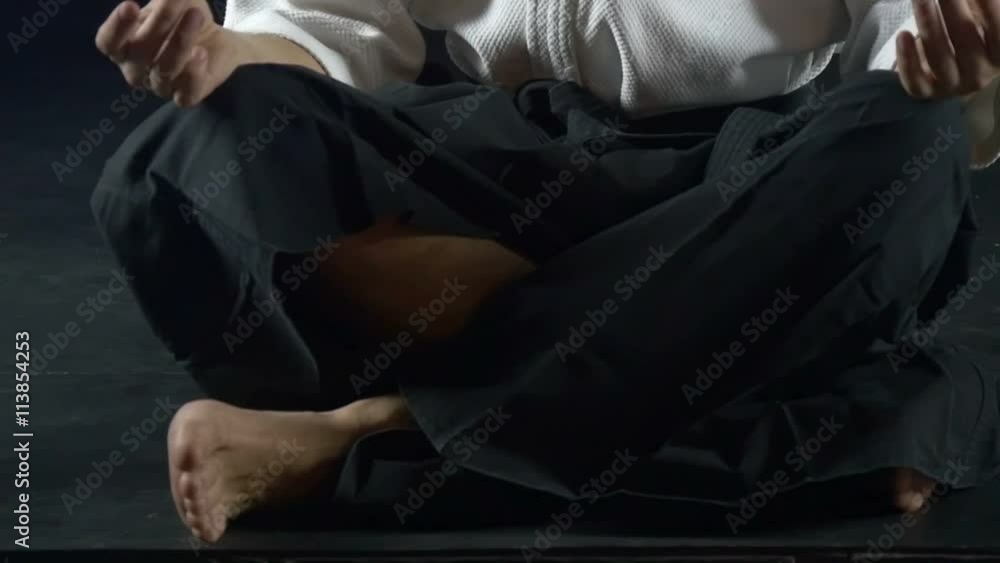 man in a kimono meditates on the floor, slow motion man in a kimono meditates on the floor, slow motion