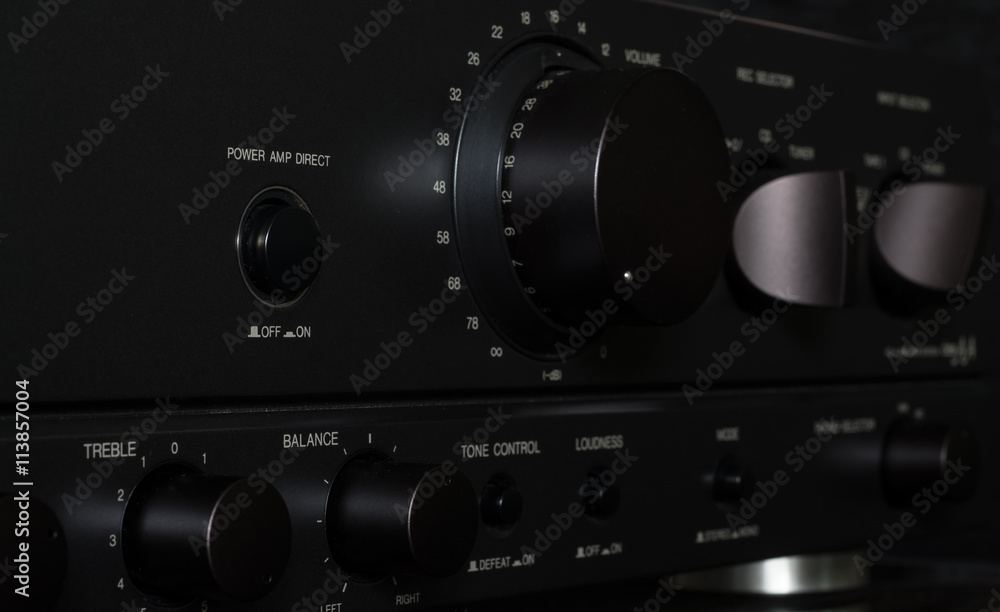 Control panel of a stereo amplifier. Metallic background. Control panel of a stereo amplifier. Metallic background.
