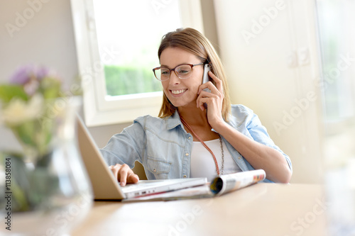 Trendy home office businesswoman talking on phone photo