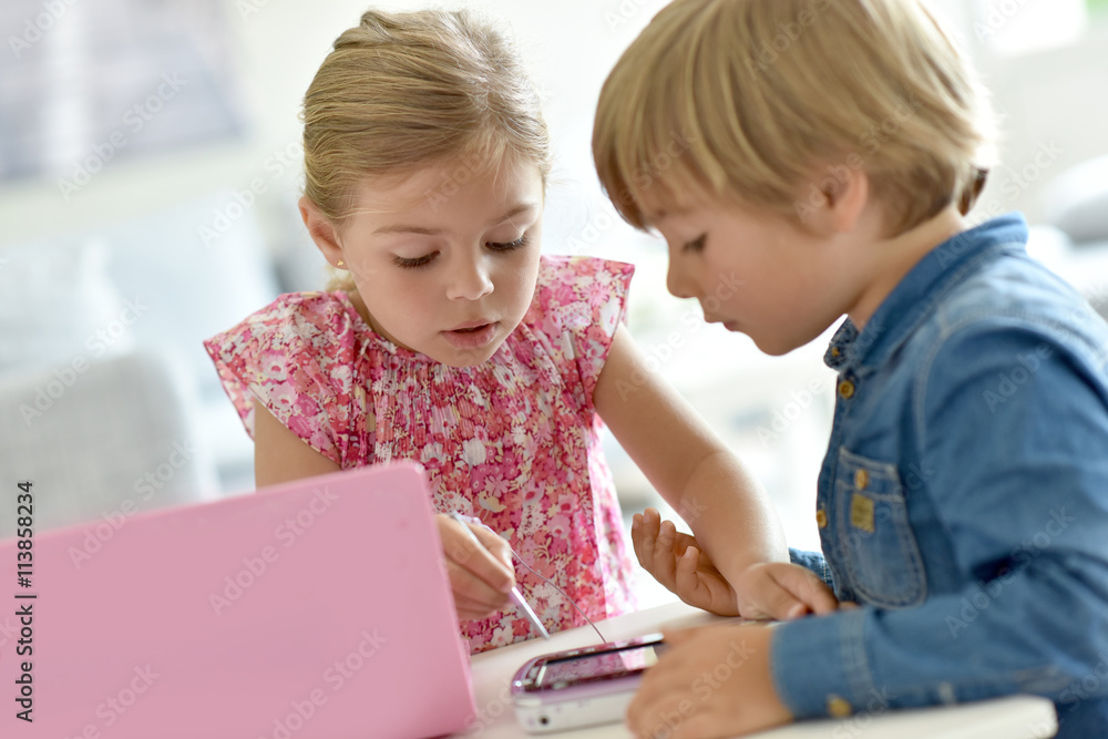 Kids playing with laptop and toy tablet Kids playing with laptop and toy tablet