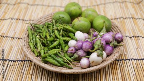 Chili , lemon and thai eggplant on craft basket