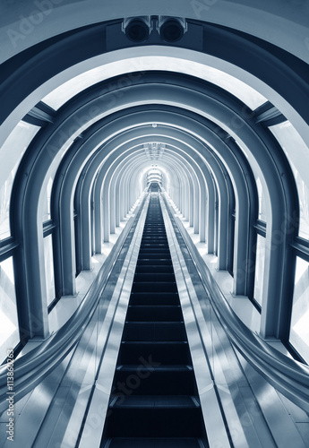 Futuristic tunnel and escalator of steel and metal, interior view. Futuristic background, business concept