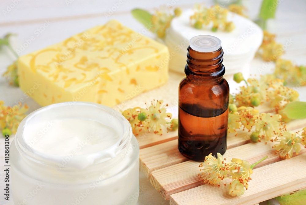 Herbal cosmetic products. Tilia (lime blossom) ethereal oil bottle, fresh facial cream, yellow soap bar.
Herbal cosmetic products. Tilia (lime blossom) ethereal oil bottle, fresh facial cream, yellow soap bar.
