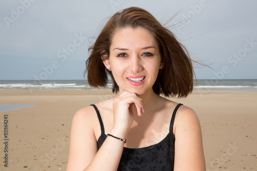 thoughtful brunette girl in black dress posing