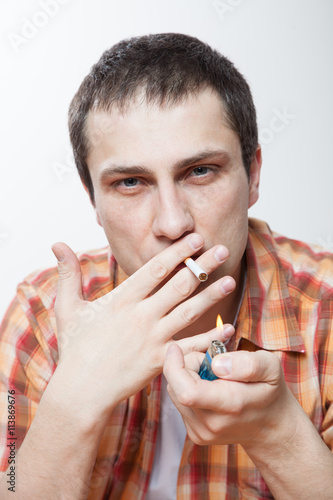 Foto Young man lighting a cigarette