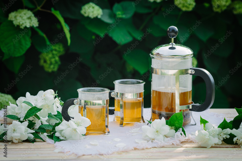 Cup of tea with jasmine, on table, on green background Cup of tea with jasmine, on table, on green background