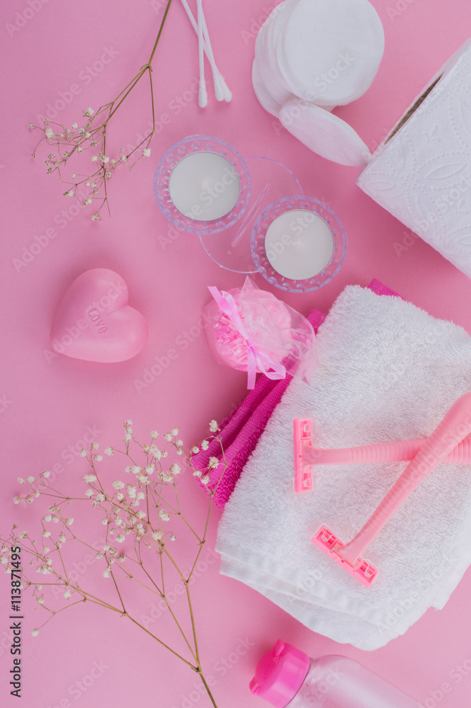 Set for SPA: cotton swabs, razors, cotton pads, towels, napkins, bath salts on a pink background flat lay. Set for SPA: cotton swabs, razors, cotton pads, towels, napkins, bath salts on a pink background flat lay.