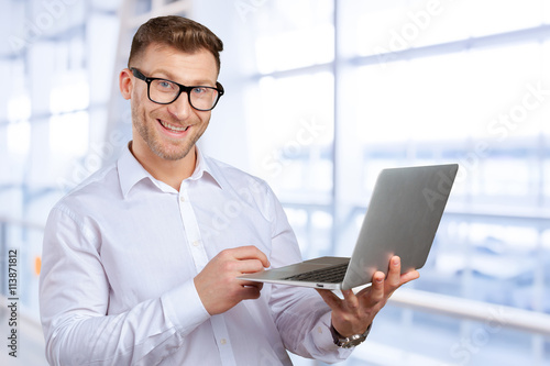 Portrait of young businessman with laptop