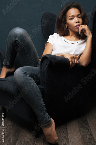 African woman sitting in blue armchair