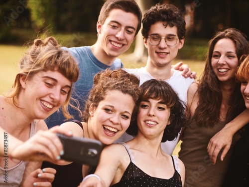 large group of friends together in a park having fun and taking a selfie