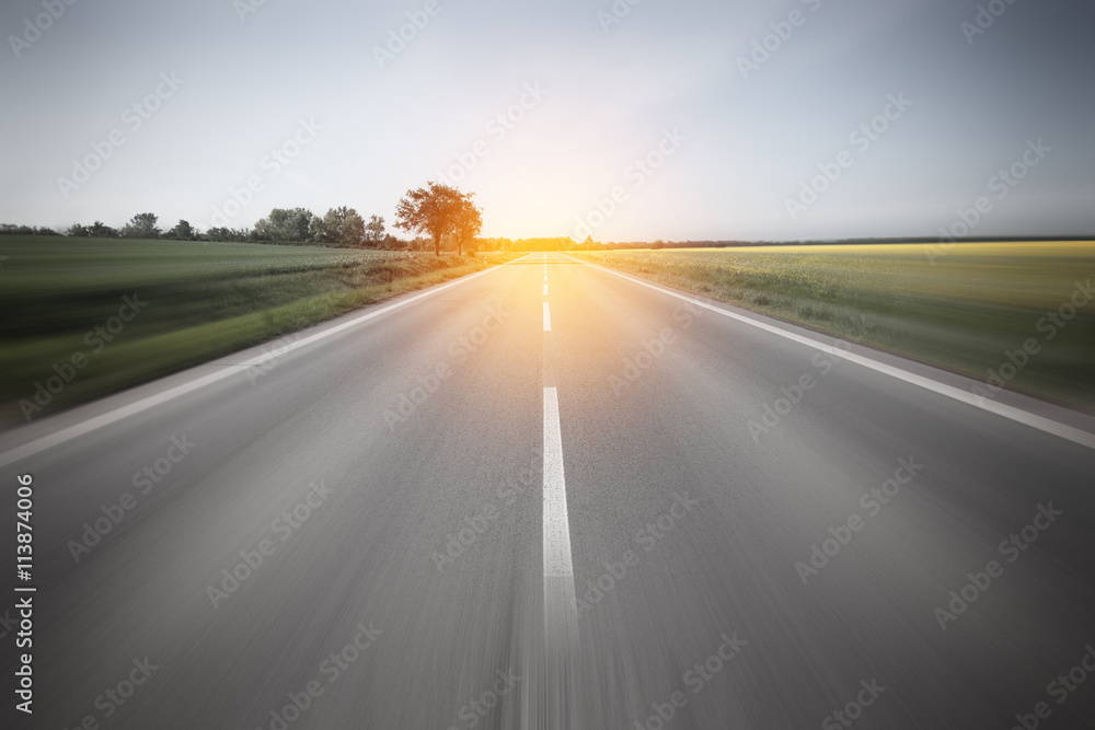 Road to the sun through the beautiful yellow field countryside l - obrazy, fototapety, plakaty 
