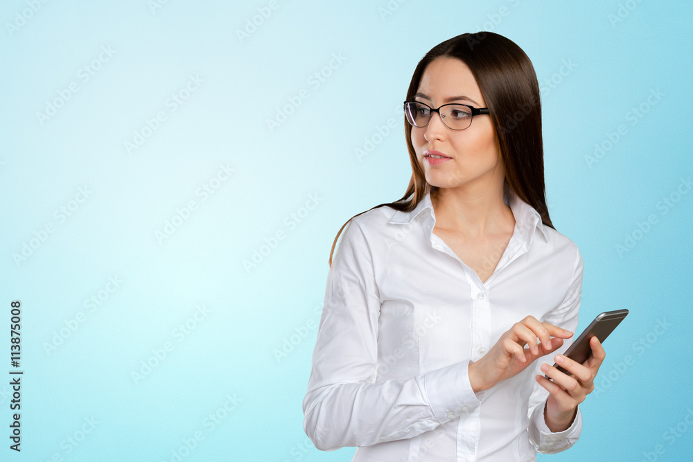 Young, confident, successful and beautiful business woman with the mobile phone isolated