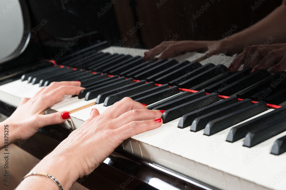 Obraz premium Mani di pianista sulla tastiera del pianoforte durante un’esecuzione