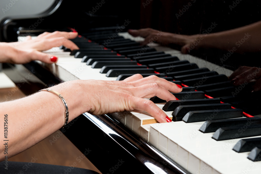 Obraz premium Mani di pianista sulla tastiera del pianoforte durante un’esecuzione