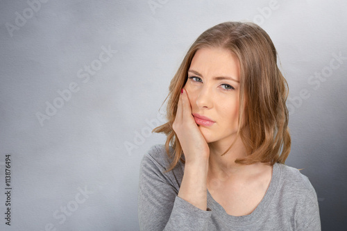 Portrait of young woman with toothache