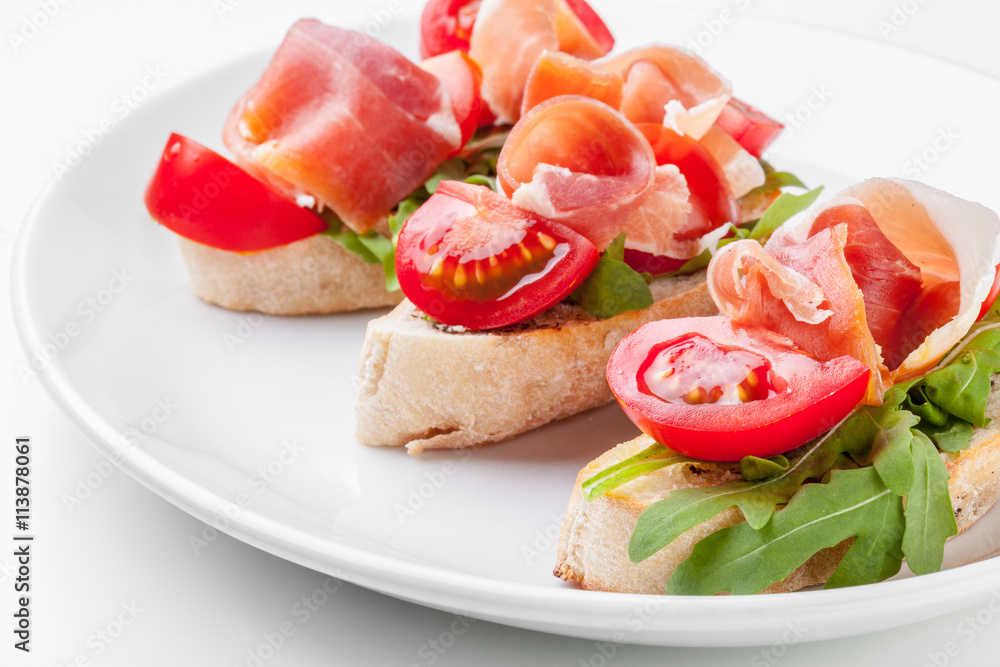 Jamon. Slices of Bread with Spanish Serrano Ham Served as Tapas. Cured ham, spanish appetizer. Prosciutto isolated on white background