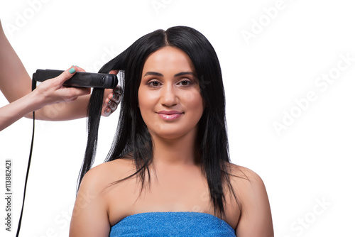 Young woman getting hair straightner isolated on white
