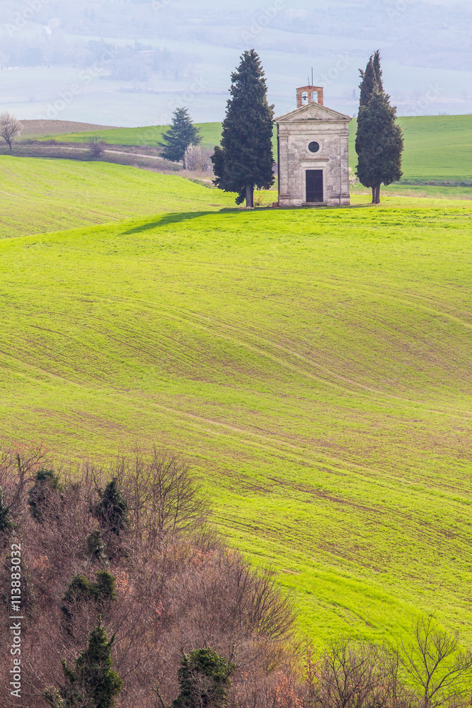 Tuscany landscape with hill, church and cypress