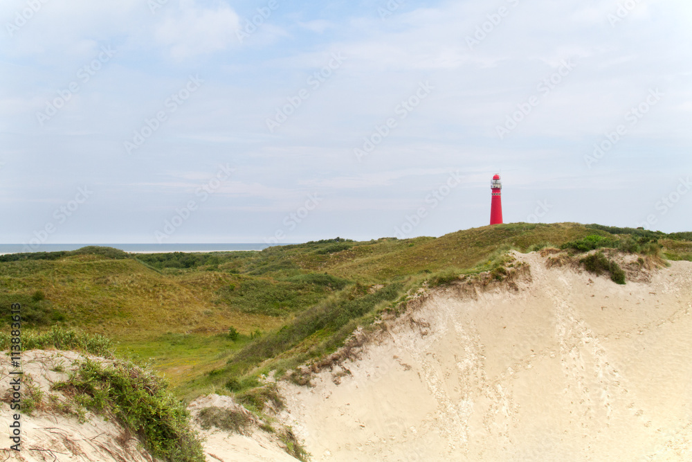 Red lighthouse in the dunes of the dutch island Schiermonnikoog Red lighthouse in the dunes of the dutch island Schiermonnikoog