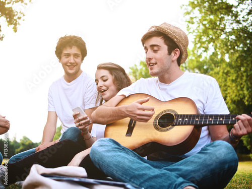 group of friends together in a park having fun and playing music with a guitar