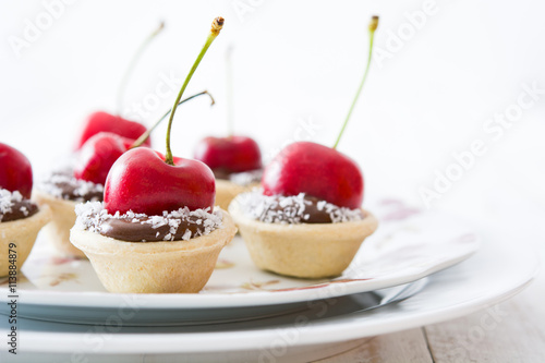 Delicious chocolate tartlets with chocolate, cherries and coconut