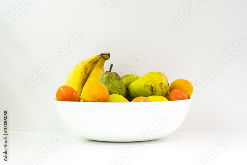 Fototapeta Naklejka Na Ścianę i Meble -  White bowl with a fruits, on a white table