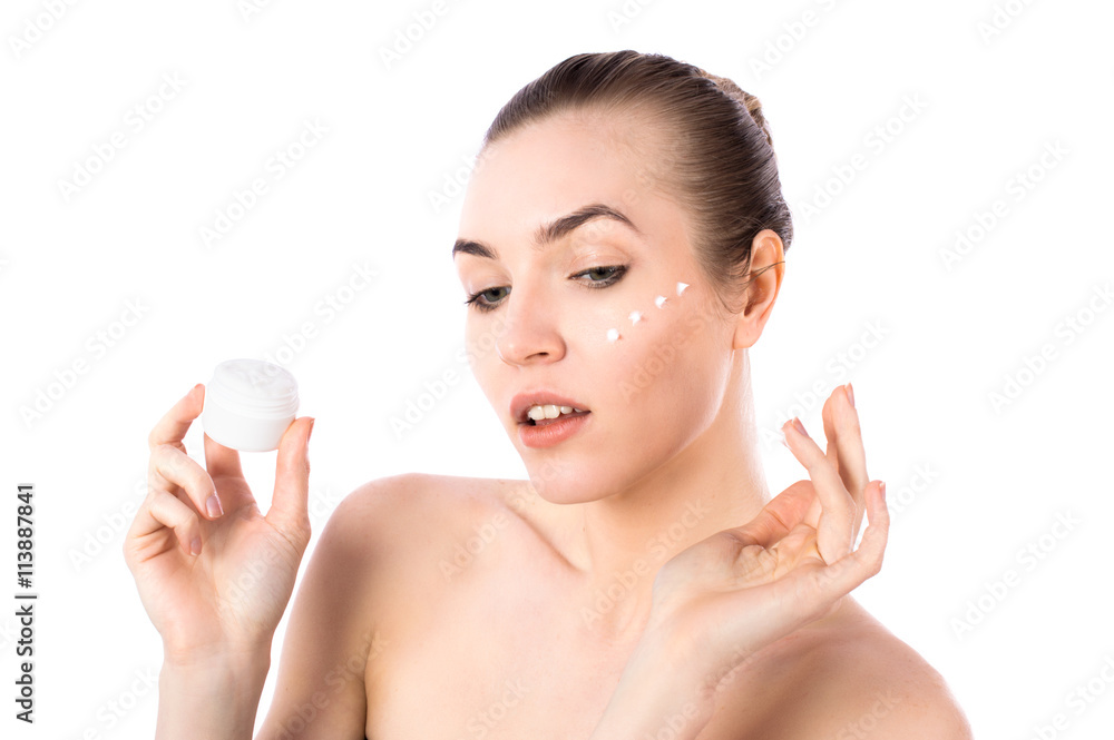 Young girl applying a natural face cream portrait isolated on white background. Skin care concept. Young girl applying a natural face cream portrait isolated on white background. Skin care concept.