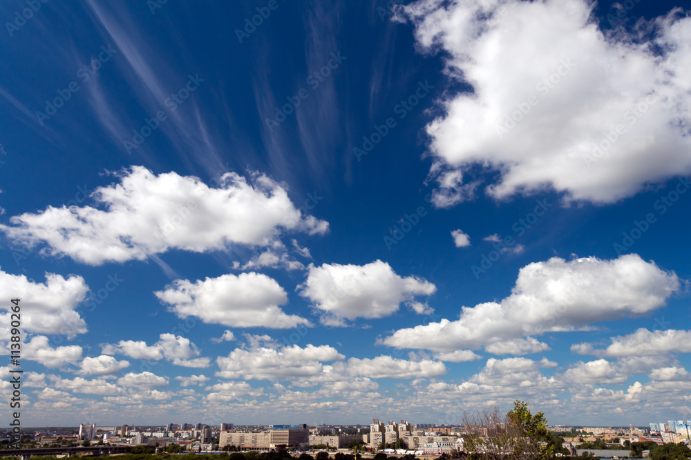 Clouds Cumulus white high in the blue sky. At the bottom a narro Clouds Cumulus white high in the blue sky. At the bottom a narro