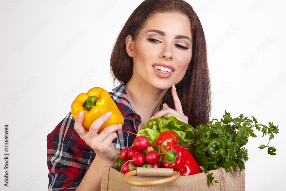 Isolated woman holding a shopping bag full of vegetables Isolated woman holding a shopping bag full of vegetables