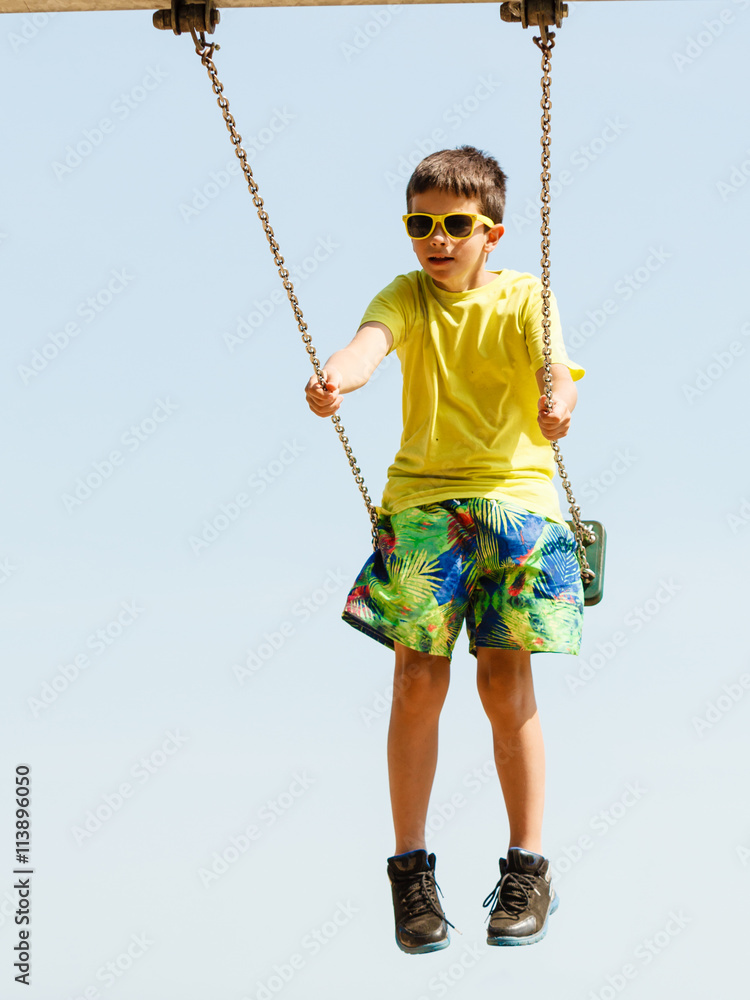 Boy playing swinging by swing-set. Boy playing swinging by swing-set.